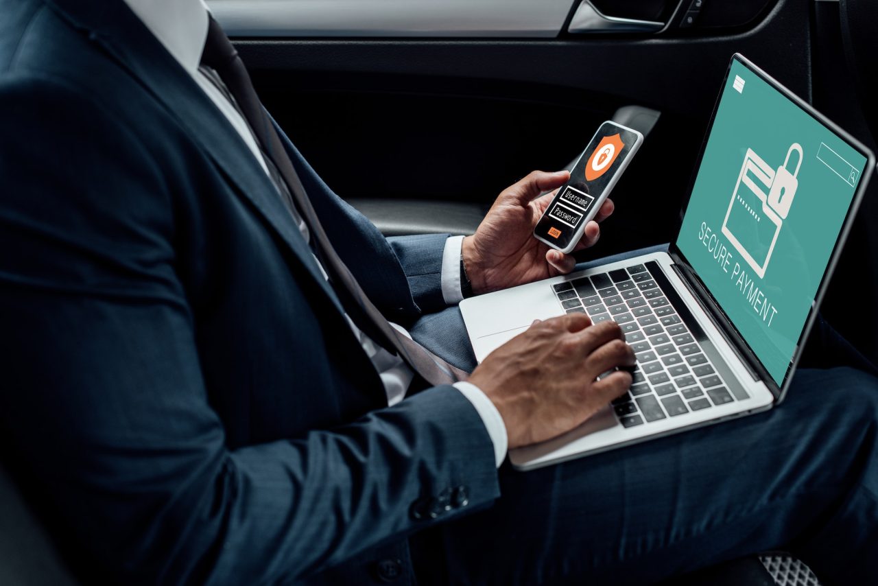 cropped-view-of-african-american-businessman-using-laptop-and-smartphone-in-car-with-cyber-security.jpg - Mass Global Media - Mass Global Media